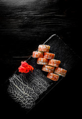 Sushi rolls with srimp and cream cheese on black wooden table background