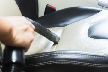 Car interior detailing hand of man brushing dust from the steering wheel.