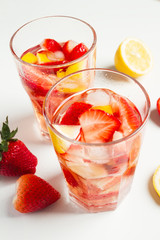Strawberry detox water with lemon on white background.