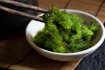 Oval sea grapes seaweed, Close up Green Caviar on dark background