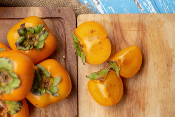 Fresh ripe persimmons on blue wooden table
