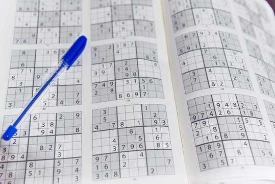 Sudoku game for free time at home with a blue pen, close up,  still life photography