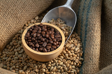 Coffee beans in canvas sack on wooden table in the dark light