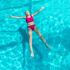 girl swims in a blue pool