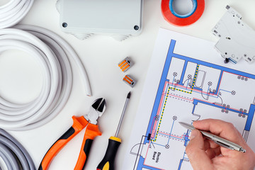 Electrician checking the electrical plans. Concept repair of electrical equipment.