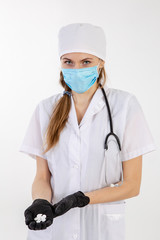 A doctor in a white coat holds out a medication.