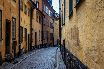 A narrow, deserted empty street paved with paving stones in the old part of the modern European...
