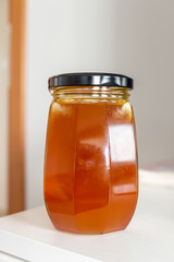 A jar of honey as a sweet cure for the virus at all times on a light table.
