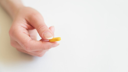 Yellow tablet on the palm of a woman. Copy space