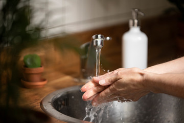 Woman washing her hand with soap