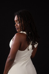 Obraz premium Pretty black woman in a white dress, looking thoughtful