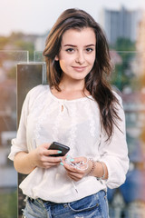 Beautiful girl using smartphone at the terrace in the restaurant