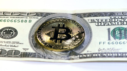 golden bitcoin coin on us dollars close up