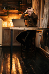 Young man with shocked expression looking at screen laptop. Male working on computer to come to solution of deep problems. Concept of lifestyle in self-isolation in Coronavirus COVID-19 Pandemic.