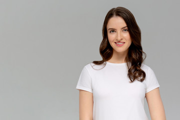 Portrait of a beautiful young girl, isolated on gray background. Studio shot.