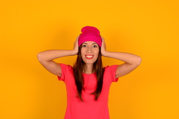 cute young woman in pink hat t-shirt on yellow background logo emotion smile