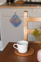 white mug against the kitchen background on the table with a blurred background. composition kitchen