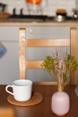 white mug against the kitchen background on the table with a blurred background. composition kitchen