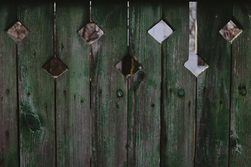 Green wood fence with square holes. Green wood background.