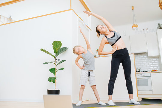 Focused mother and son doing side bends exercise, keeping fit - Powered by Adobe