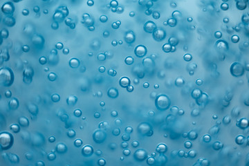 Many round bubbles of the shower gel on the blue background.
