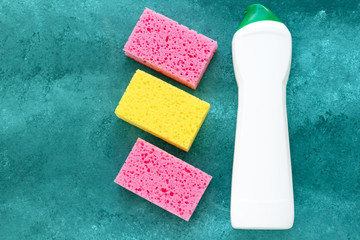 Colorful sponges for washing dishes, cleaner bottle for cleaning. Disinfection concept.