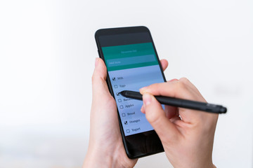 Unrecognizable woman doing online shopping from the house. Groceries application to buy food and stay home during pandemic time. Coronavirus covid - 19 concept.