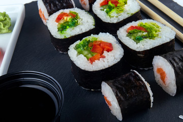 Appetizing vegetarian sushi set on a black plate