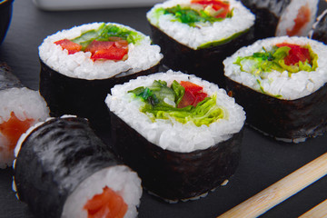 Appetizing, colorful vegetarian sushi set on a black plate