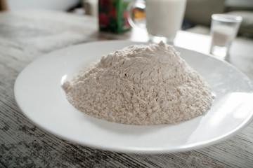 Plate with flour on a light background close-up
