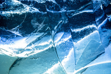 Abstract ice background. Blue background with cracks on the ice surface
