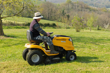 Tonte de la pelouse en ce jour de printemps pour ce jardinier afin d'embellir ce jardin paysagé