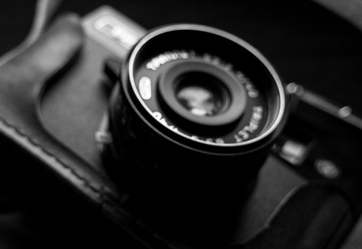 An old camera with an open lens. blurred black and white photo