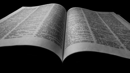 Fototapeta premium Book opened blurred black and white photo. dark background