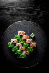 set of Sushi rolls with seafood, srimp, cream cheese,caviar and Chuka salad on black wooden table background