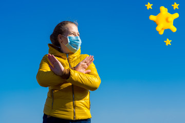 a girl in a medical mask holds her arms crossed in front of her while urging the coronavirus...