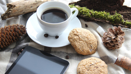Working in harmony with nature during the coronavirus outbreak concept selective focus of coffee cup, chocolate cookies, pine cone, tablet, headphones and other nature themed objects
