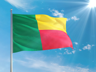 Benin national flag waving in the wind against deep blue sky. High quality fabric. International relations concept.