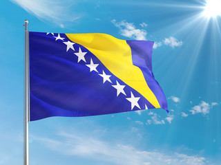 Bosnia Herzegovina national flag waving in the wind against deep blue sky. High quality fabric. International relations concept.