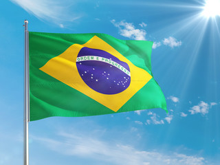 Brazil national flag waving in the wind against deep blue sky. High quality fabric. International relations concept.
