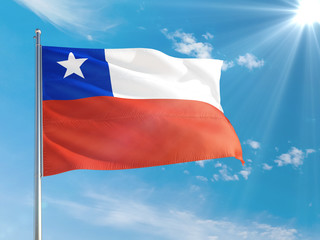 Chile national flag waving in the wind against deep blue sky. High quality fabric. International relations concept.