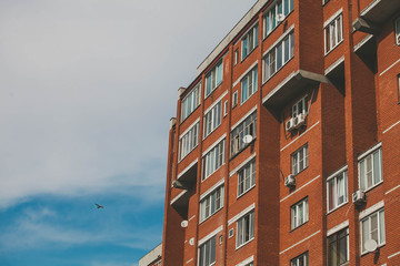 red brick apartment building against a blue sky