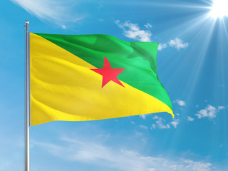 French Guiana national flag waving in the wind against deep blue sky. High quality fabric. International relations concept.