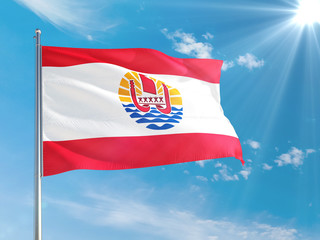 Naklejka na ściany i meble French Polynesia national flag waving in the wind against deep blue sky. High quality fabric. International relations concept.