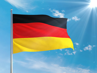 Germany national flag waving in the wind against deep blue sky. High quality fabric. International relations concept.