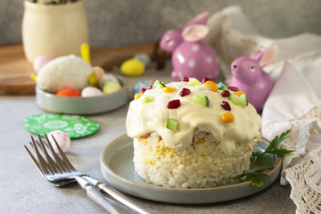 Holiday salad is not a sweet cake. Salad with rice, egg, crab sticks and cucumber on a stone or concrete on a light countertop.