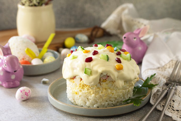 Holiday salad is not a sweet cake. Salad with rice, egg, crab sticks and cucumber on a stone or concrete on a light countertop.