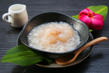 Sticky rice boiled in syrup with longan and coconut milk dressing. Thai dessert