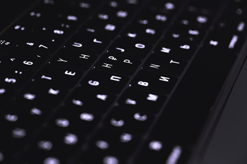 glowing keyboard of a modern notebook, laptop on the dark closeup