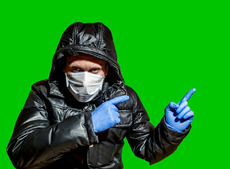 A  man in a medical mask and protective gloves shot in isolation on a green background